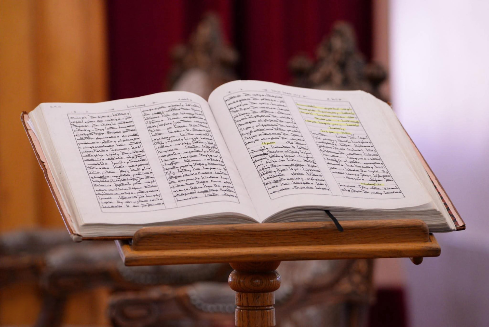 Open Syriac liturgical book on a wooden lectern